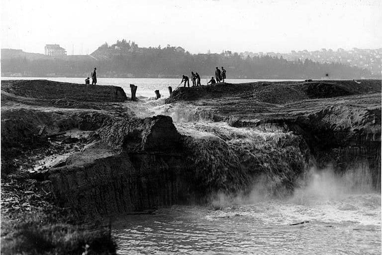 Cutting away the cofferdam at the Montlake Cut between Lake Washington and Lake Union. December 1913. Photographer unknown.