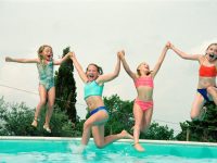 girls jumping into swimming pool