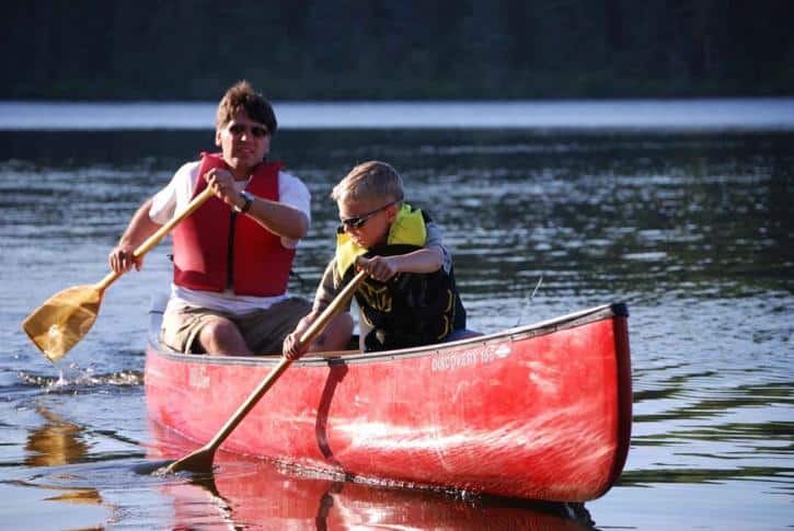 father and son canoeing on a river