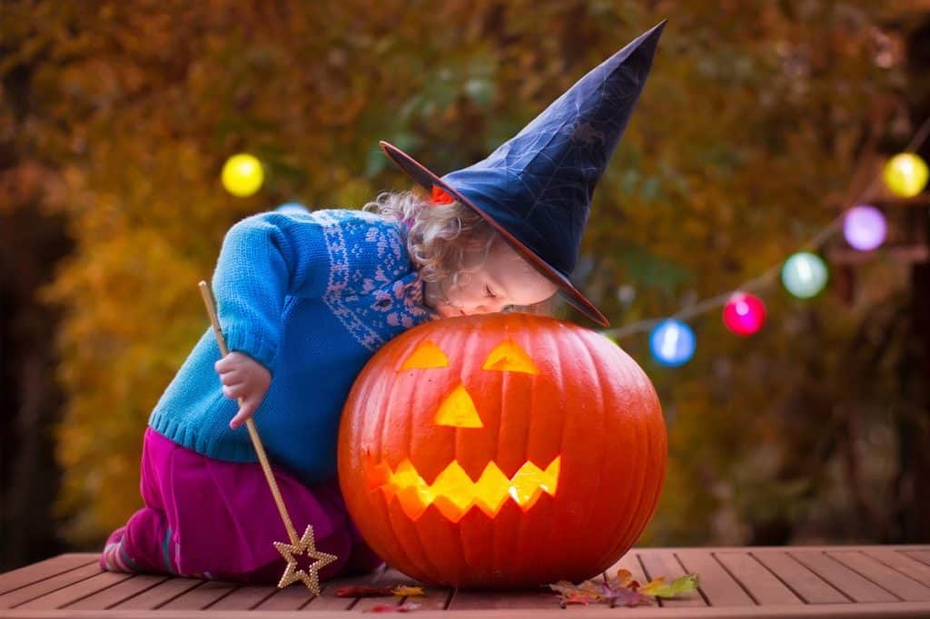 Young girl peers into a Halloween pumpkin