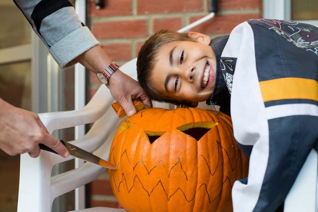 Mother and son carving jack-o-lantern pumpkin