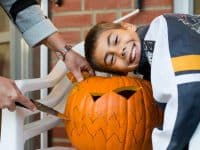 Mother and son carving jack-o-lantern pumpkin