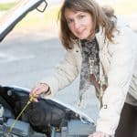 Woman checking oil level in her car
