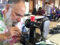 man repairing sewing machine