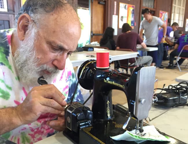 man repairing sewing machine