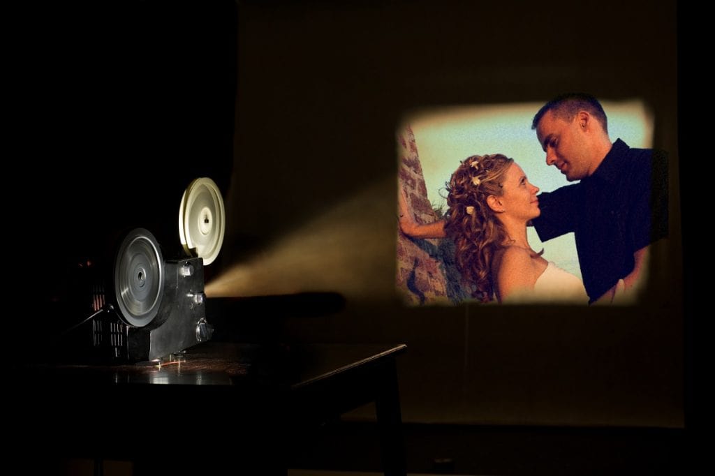 Old-fashioned film projector showing movie on a screen