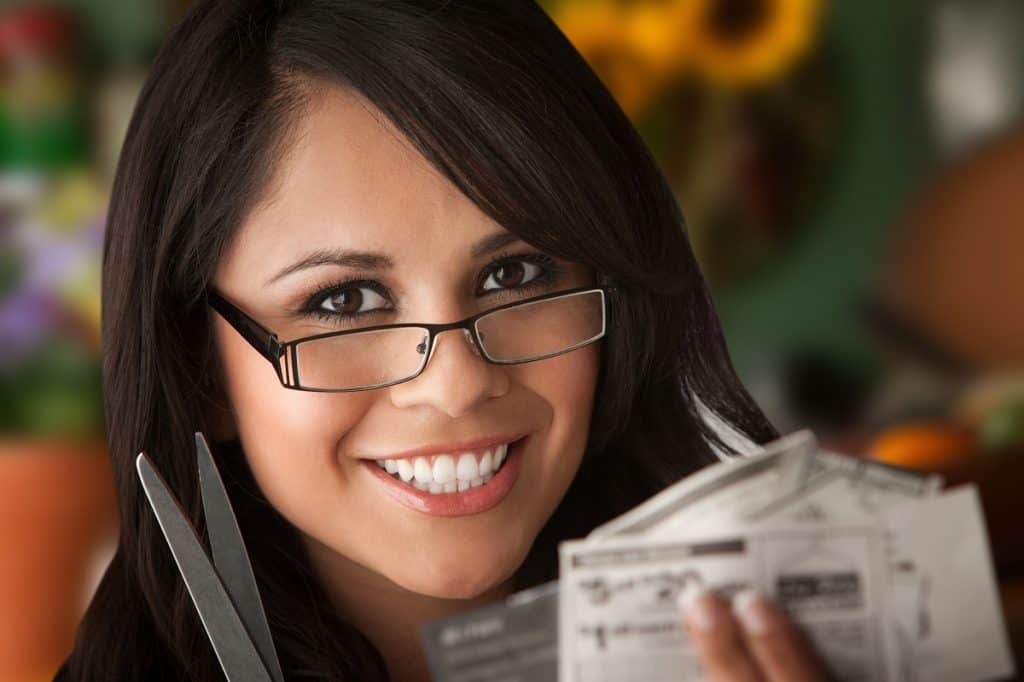 Woman saves money by clipping coupons photo by creatista - DepostiPhotos.com