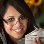 Woman saves money by clipping coupons photo by creatista - DepostiPhotos.com