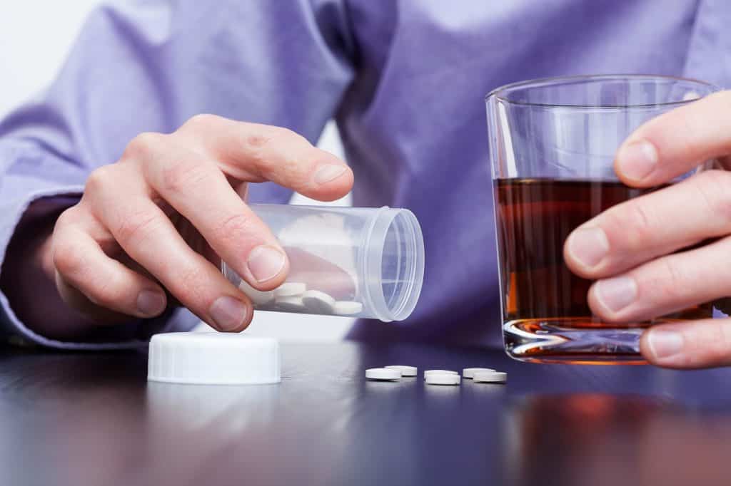 Man drinking alcohol and taking pills photo by photographee.eu - DepositPhotos.com