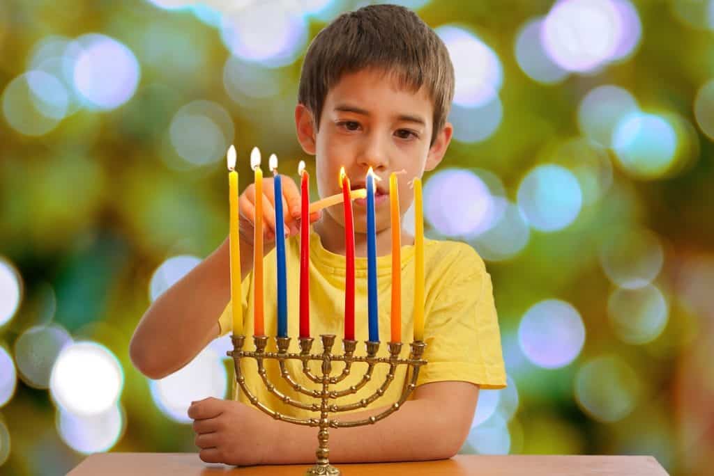 Jewish Boy lighting a Hanukkah Menorah