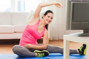 woman exercsing at home using a video - DepositPhotos.com
