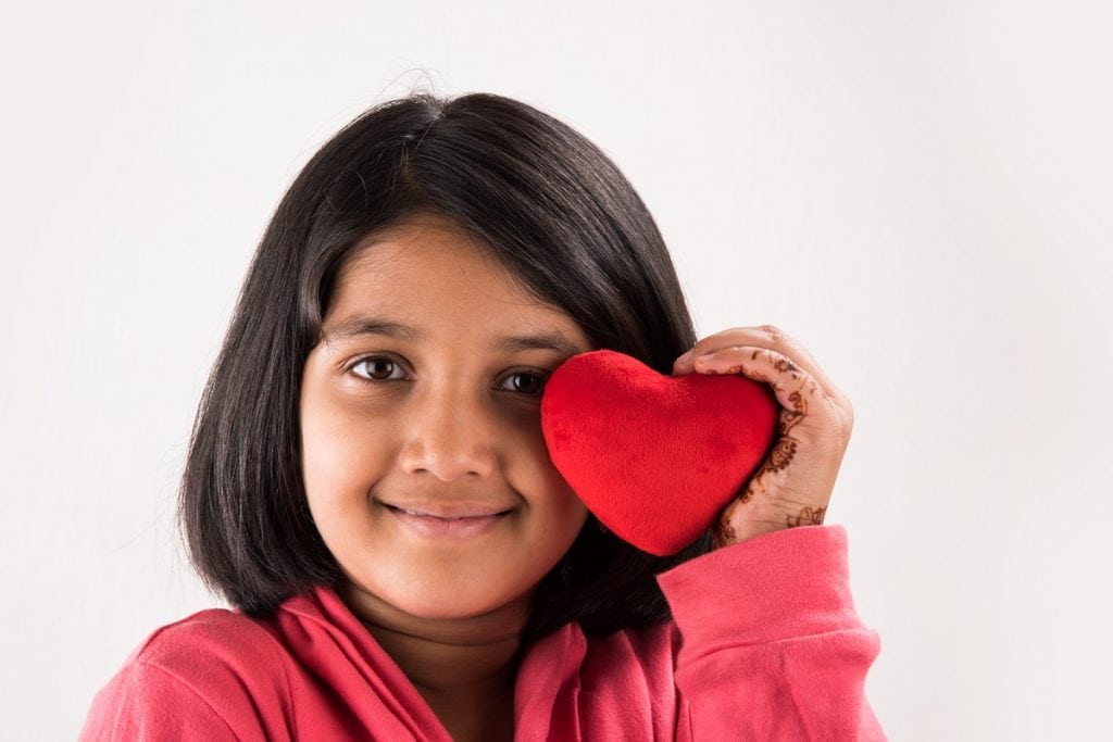 young girl with red valentine heart