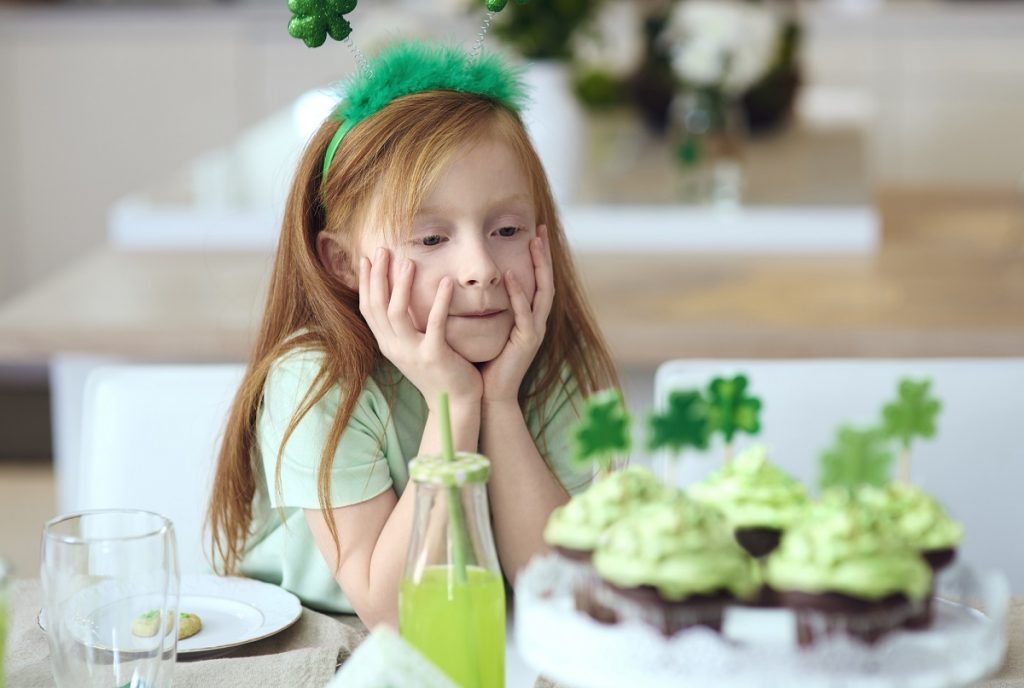 Young girl admiring St. Patrick's Day cupcakes