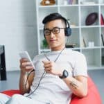 Young man listening with headphones. Photo by VitalikRadko - DepositPhotos.com