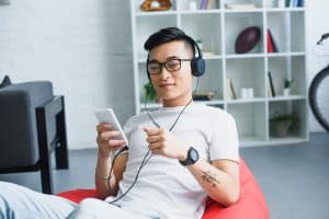 Young man listening with headphones. Photo by VitalikRadko - DepositPhotos.com