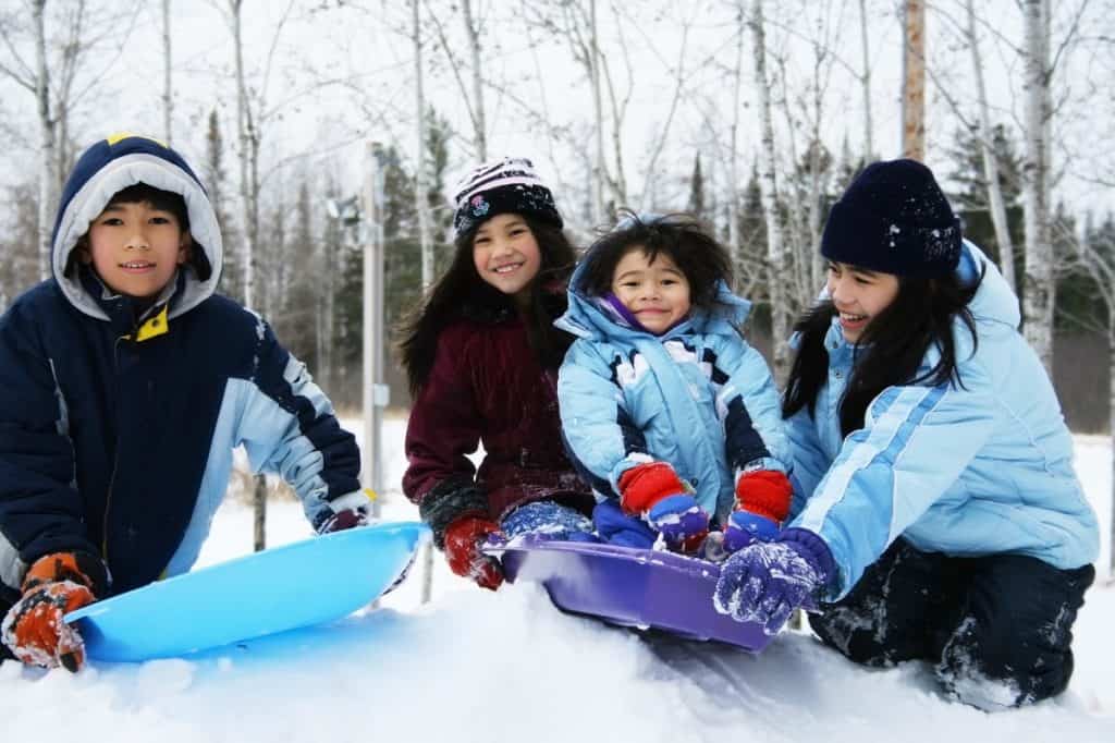 Family enjoying a snow day in the park - DepositPhotos.com