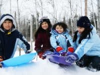 Family enjoying a snow day in the park - DepositPhotos.com