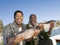 Father and son fishing, showing off their catch