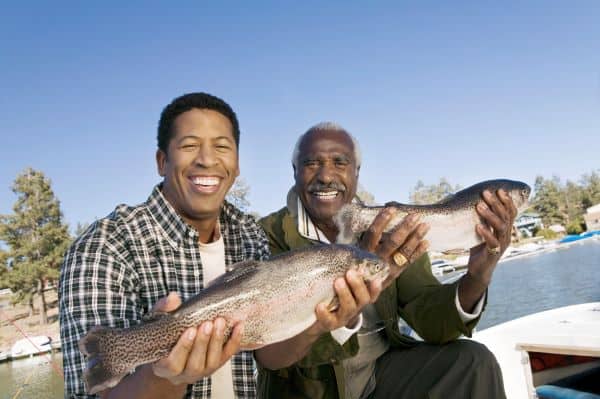 Father and son fishing, showing off their catch