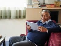 man using tablet computer at home