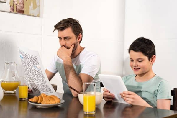 Father and son reading at breakfast