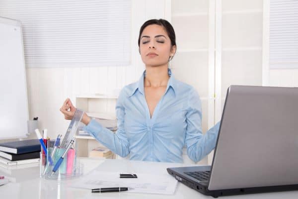 woman meditating at work at her desk