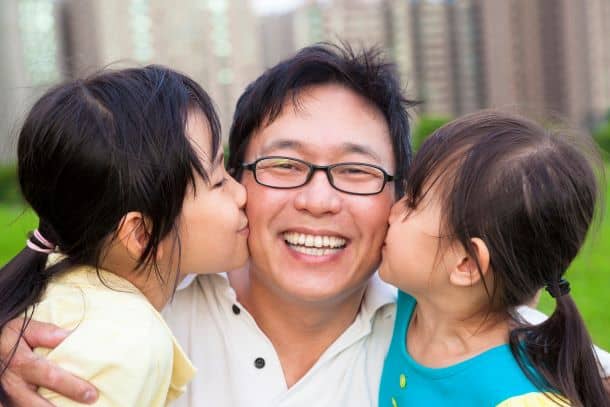 children kissing their father