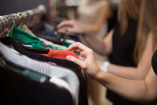 people looking through clothes rack while shopping