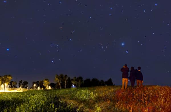 Stargazing with binoculars in a field