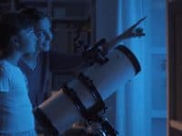 Mother and daughter stargazing with a telescope