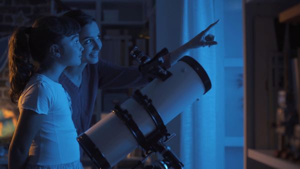 Mother and daughter stargazing with a telescope