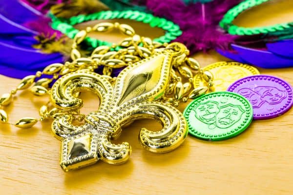 mardi gras trinkets (fleur de lis, coins, beads, mask)