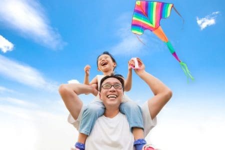 father and daughter flying a kite