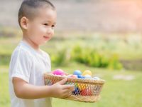 young boy with a basket of colorful easter eggs