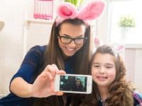 Mother and daughter wearing bunny ears taking a selfie photo