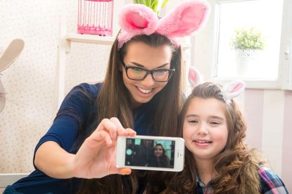 Mother and daughter wearing bunny ears taking a selfie photo