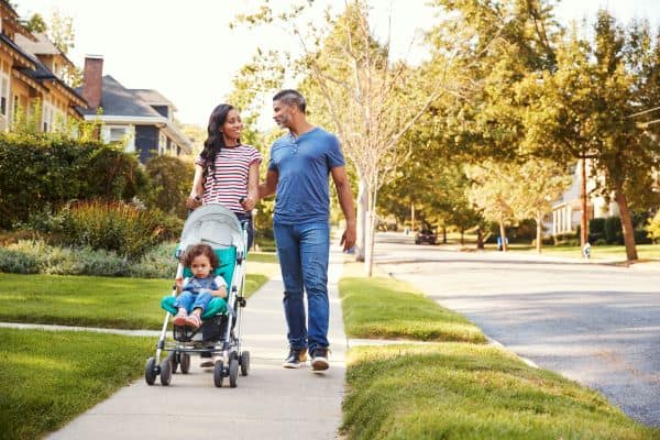 couple walking with child in stroller