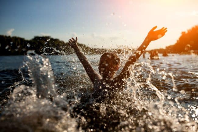 children swimming in a lake 