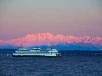 Washington State Ferry crossing Puget Sound in winter with dawn alpenglow