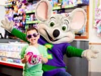 Young boy with a mouse character at Chuck E. Cheese