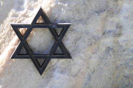 Star of David metal sculpture on rock wall