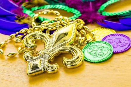 mardi gras trinkets (fleur de lis, coins, beads, mask)